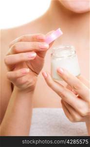 Skincare. Closeup of woman holding lotion jar. Blond girl taking care of her dry complexion applying moisturizing cream isolated. Beauty treatment.