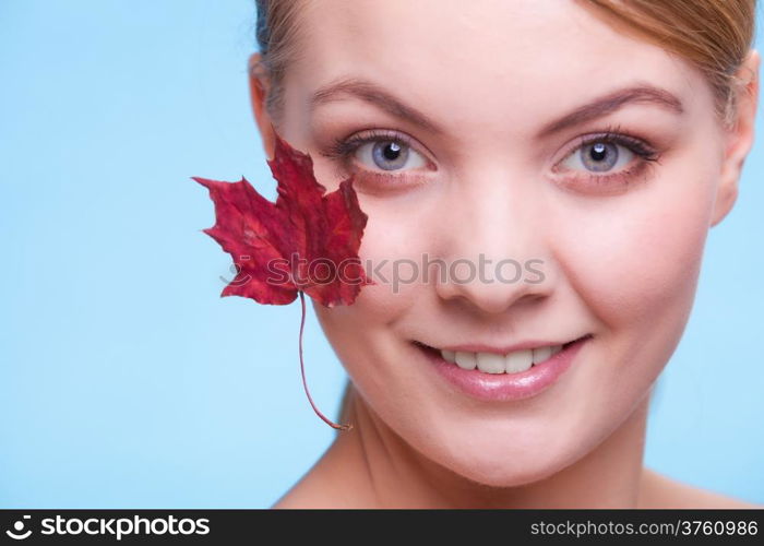 Skincare habits. Portrait of young woman with leaf as symbol of red capillary skin on blue. Face of girl taking care of her dry complexion. Studio shot.