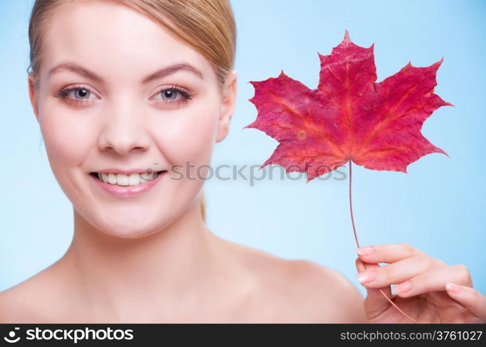 Skincare habits. Portrait of young woman with leaf as symbol of red capillary skin on blue. Face of girl taking care of her dry complexion. Studio shot.