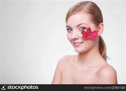 Skincare habits. Portrait of young woman with leaf as symbol of red capillary skin on gray. Face of girl taking care of her dry complexion. Studio shot.