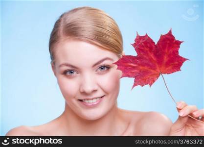 Skincare habits. Portrait of young woman with leaf as symbol of red capillary skin on blue. Face of girl taking care of her dry complexion. Studio shot.
