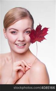 Skincare habits. Portrait of young woman with leaf as symbol of red capillary skin on gray. Face of girl taking care of her dry complexion. Studio shot.