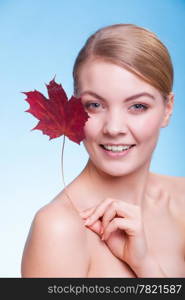 Skincare habits. Portrait of young woman with leaf as symbol of red capillary skin on blue. Face of girl taking care of her dry complexion. Studio shot.