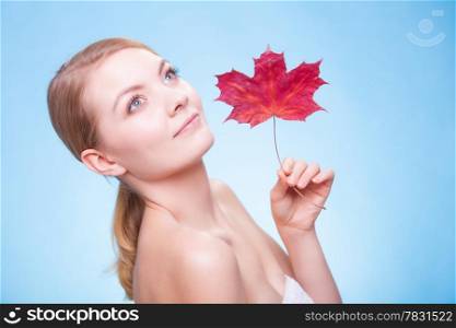Skincare habits. Portrait of young woman with leaf as symbol of red capillary skin on blue. Face of girl taking care of her dry complexion. Studio shot.
