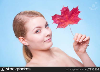 Skincare habits. Portrait of young woman with leaf as symbol of red capillary skin on blue. Face of girl taking care of her dry complexion. Studio shot.