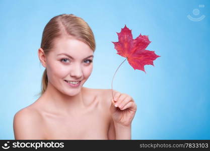 Skincare habits. Portrait of young woman with leaf as symbol of red capillary skin on blue. Face of girl taking care of her dry complexion. Studio shot.