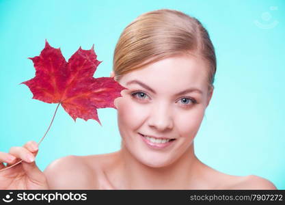 Skincare habits. Portrait of young woman with leaf as symbol of red capillary skin on turquoise. Face of girl taking care of her dry complexion. Studio shot.