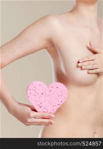 Skincare hygiene medicine and body treatment. Sensual naked woman with beautiful figure perfect skin holding pink heart shaped sponge in hands.. Naked woman holding pink heart sponge in hands.