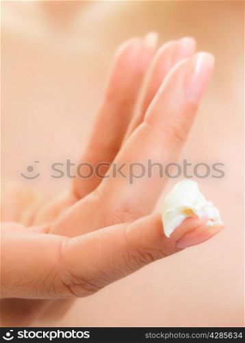 Skincare. Woman taking care of her dry complexion. Moisturizing cream on female hand isolated. Beauty treatment.