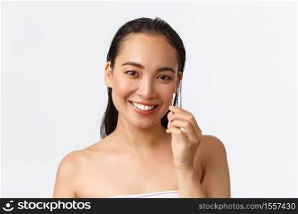 Skincare, women beauty, hygiene and personal care concept. Close-up of beautiful asian girl standing naked in bathroom or shower, holding cotton buds, swabs for ears, standing white background.. Skincare, women beauty, hygiene and personal care concept. Close-up of beautiful asian girl standing naked in bathroom or shower, holding cotton buds, swabs for ears, standing white background