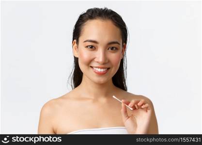 Skincare, women beauty, hygiene and personal care concept. Close-up of beautiful asian girl standing naked in bathroom or shower, holding cotton buds, swabs for ears, standing white background.. Skincare, women beauty, hygiene and personal care concept. Close-up of beautiful asian girl standing naked in bathroom or shower, holding cotton buds, swabs for ears, standing white background
