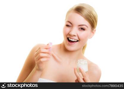 Skincare. Young woman holding lotion jar. Blond girl taking care of her dry complexion applying moisturizing cream isolated. Beauty treatment.