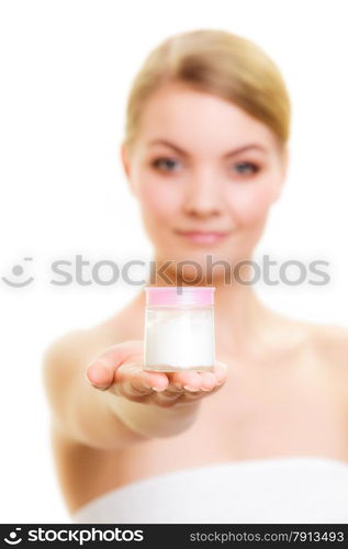 Skincare. Young woman holding lotion jar. Blond girl taking care of her dry complexion applying moisturizing cream isolated. Beauty treatment.