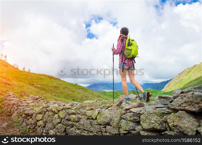 Skinny girl in shorts practice trekking alone in the beautiful mountain landscape in summer