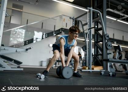 Skinny nerd wimp grimacing trying to lift heavy dumbbells while training at sports gym. Skinny nerd wimp trying to lift heavy dumbbells at gym