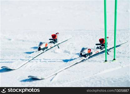 Skis and poles sticking out of the snow closeup, nobody. Winter active sport concept. Mountain skiing equipment