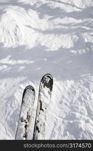 Skis dangling on top of trail drop.