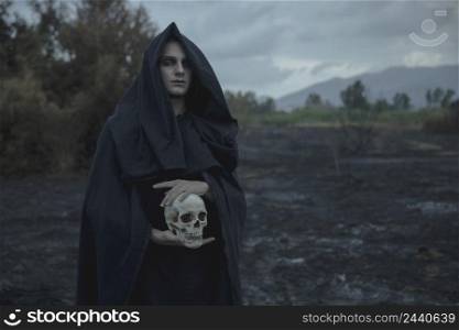 skull being held by male mage black clothes