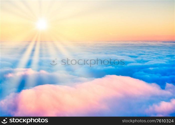 Sky and clouds at sunset with sun rays, aerial view from plane