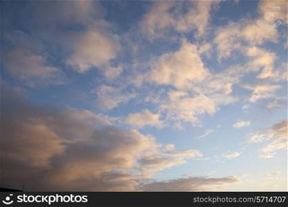 Sky background with warm sunset clouds.