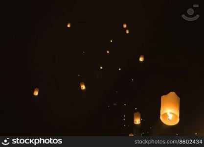 Sky lanterns glowing against black night sky, Pai, Thailand