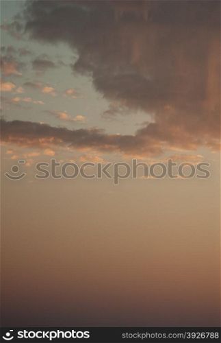 Sky with a few clouds at sunset.The sky of the so-called golden hour.Sky in blue-red and a few dark clouds at the bottom of the frame.Vertical view.