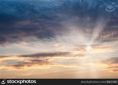 Sky with cirrus clouds, penetrating the rays of the sun through the clouds. Sun rays passing through the clouds