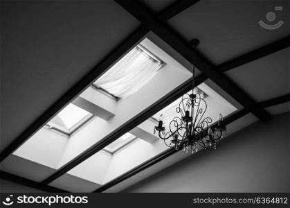 skylights in the roof of the house with a vintage chandelier on the ceiling