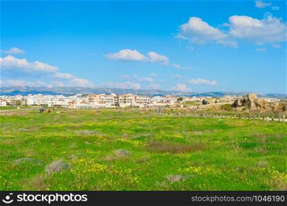 Skyline of Paphos with green field and Paphos Mosaics in the foreground, Cyprus