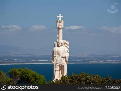 Skyline of San Diego in background behind statue of Cabrillo on Point Loma