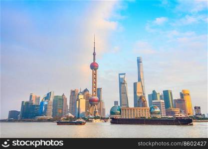 Skyline of Shanghai with barges by metropolis waterfront at sunset, China