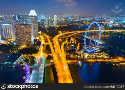 Skyline of Singapore with famous Singapore Ferries Wheel at twilight