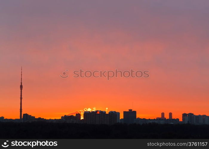 skyline with early red dawn over city in spring morning