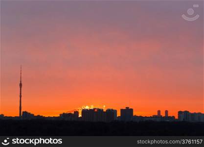 skyline with early red dawn over city in spring morning