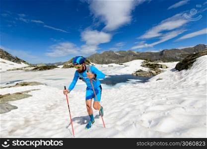 Skyrunner man in action going uphill on snow