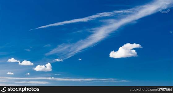 Skyscape or cloudscape. Beautiful deep blue sky with white fluffy clouds as nature background. Weather.