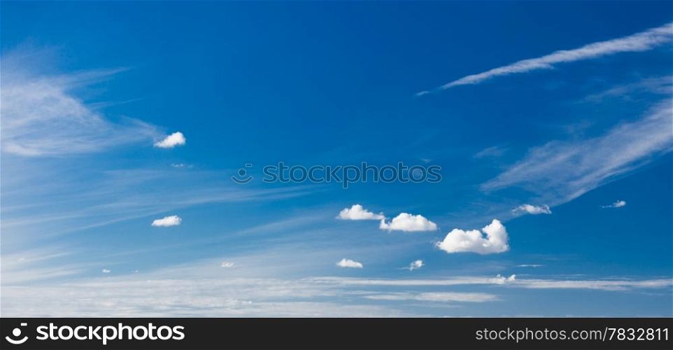 Skyscape or cloudscape. Beautiful deep blue sky with white fluffy clouds as nature background. Weather.