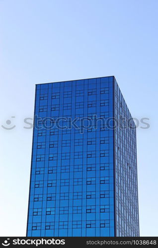 Skyscraper in Lodz. Tall skyscraper with blue windows in Lodz. Modern building with equal windows standing in Polish city Lodz. Modern skyscraper with equal windows standing in Polish city Lodz