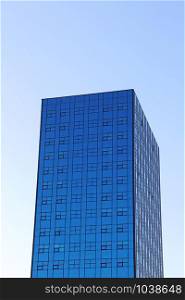 Skyscraper in Lodz. Tall skyscraper with blue windows in Lodz. Modern building with equal windows standing in Polish city Lodz. Modern skyscraper with equal windows standing in Polish city Lodz