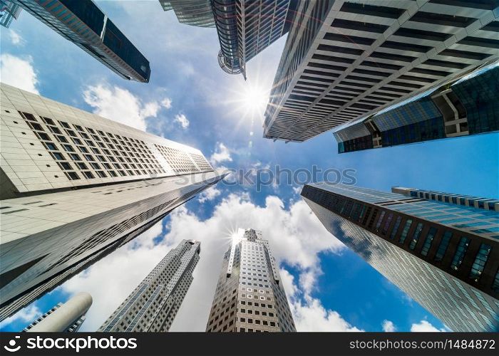 Skyscraper tower buildings in business district, Singapore city. Cloud and sun flares on sunny day sky. Low angle view. Asia financial economy, merger & acquisition, or modern architecture concept