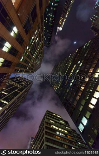 Skyscrapers and office buildings in a modern city skyline at night