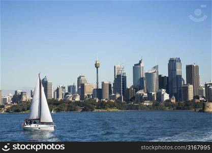 Skyscrapers and sailboat on Sydney Harbour in Sydney, Australia.