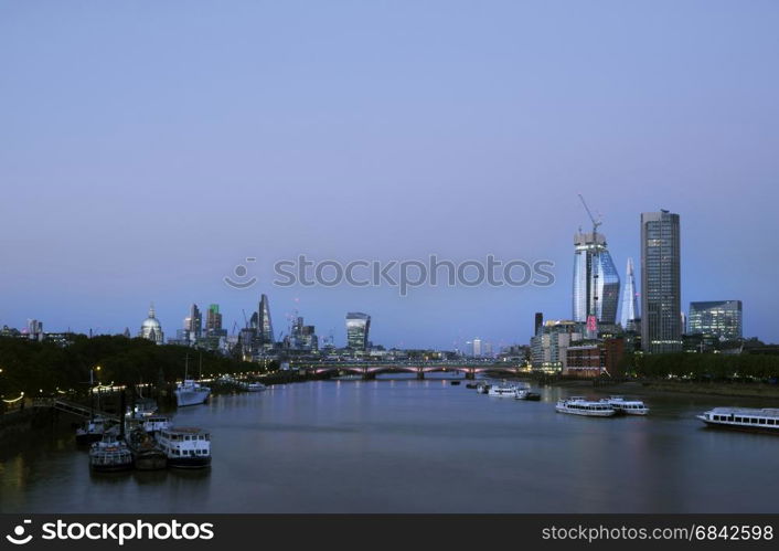 skyscrapers in london city with st paul's cathedral at night behind blackfriars bridge over thames river