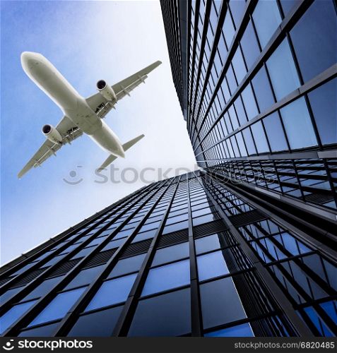 Skyscrapers with a flying airplane against blue sky
