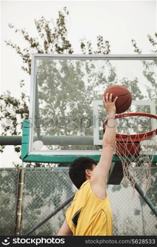 Slam dunk by young man