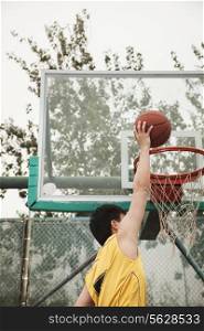 Slam dunk by young man
