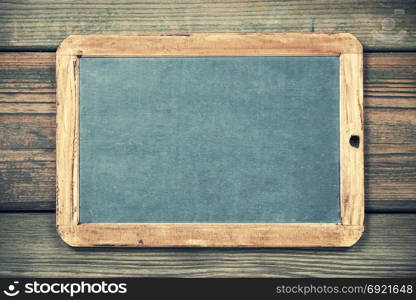 Slate blackboard against old wood. Close up