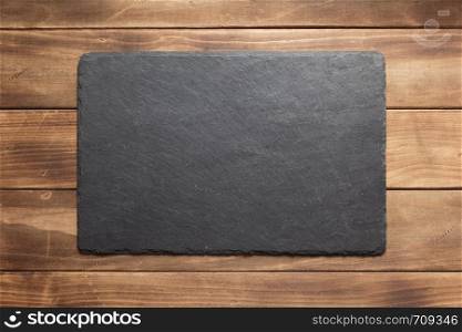 slate stone sign board at wooden plank, background texture surface