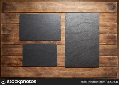 slate stone sign board at wooden plank, background texture surface