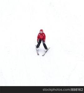 Slavske, Ukraine - December 24, 2019: Male Skier skiing downhill in high mountains. Concept of Winter sports and leasure activities. Male Skier skiing downhill in high mountains